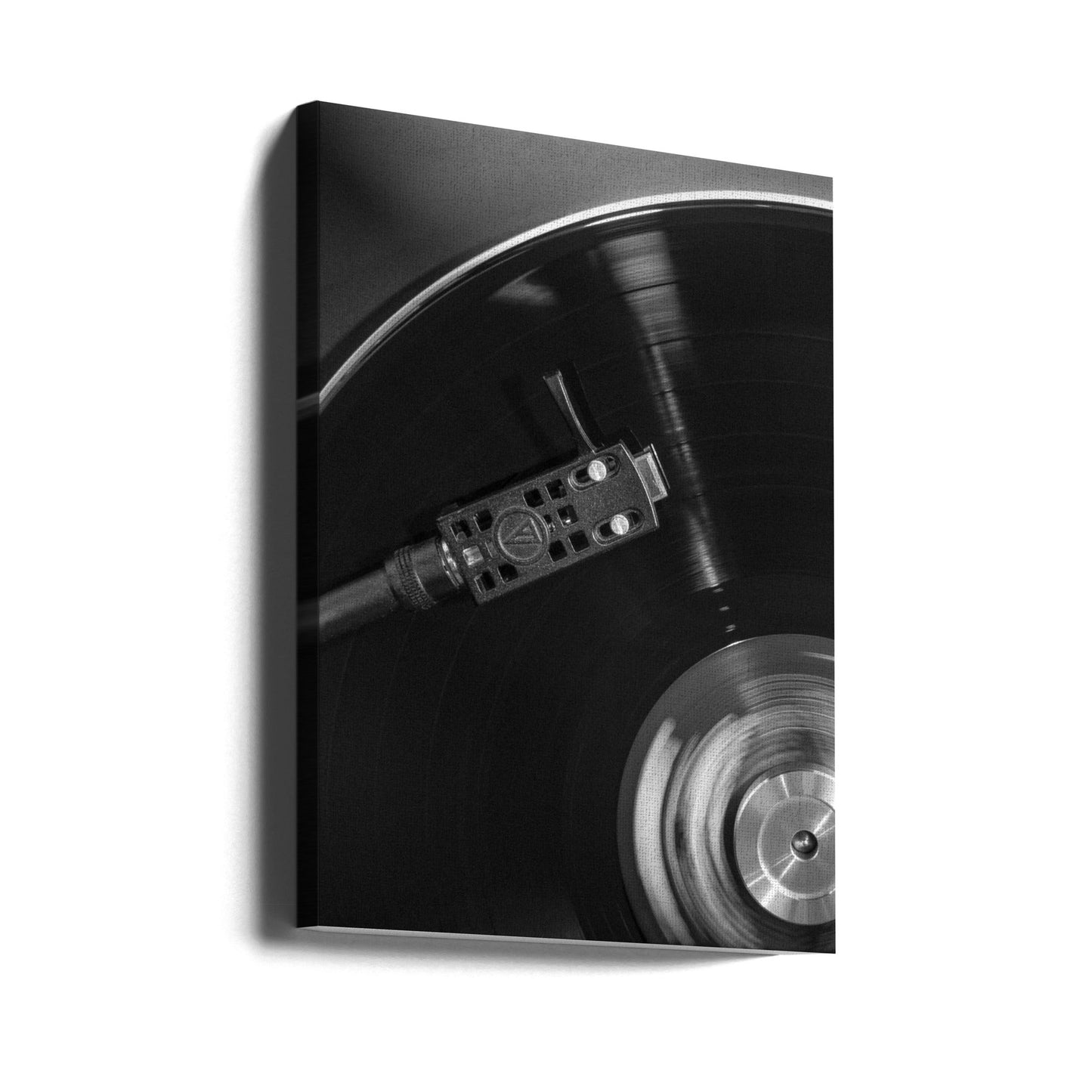 Black and white close-up of a vinyl record player with a spinning record.