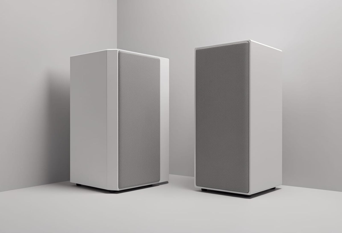 Two floorstanding speakers positioned at different distances from a wall in a small room, illustrating speaker placement variation.