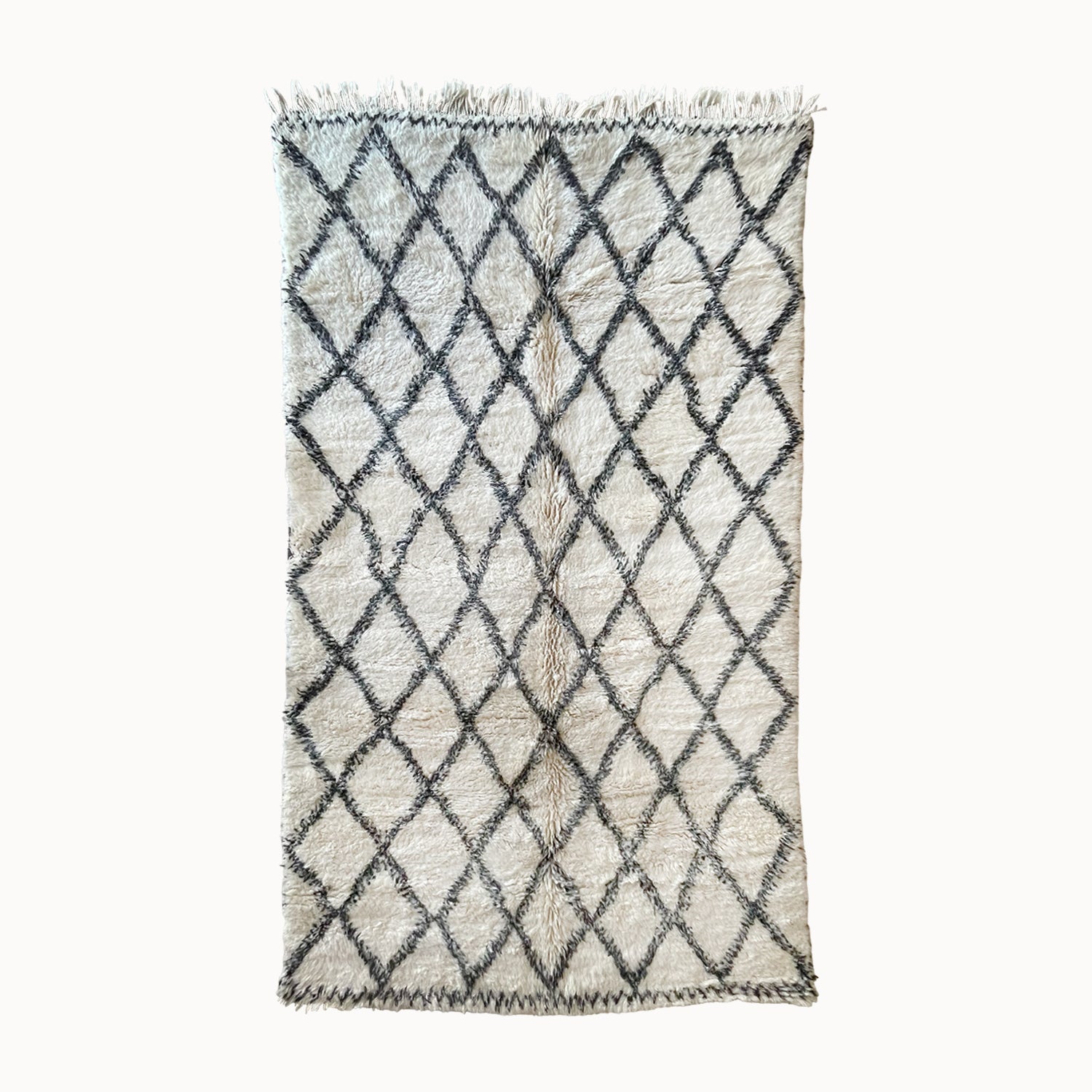 Woven rug with diamond pattern on a white background